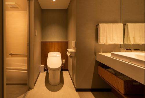 a bathroom with a toilet and a sink at Shizutetsu Hotel Prezio Tokyo Tamachi in Tokyo