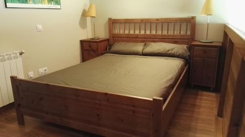 a bedroom with a large wooden bed and two night stands at Dúplex Àreu, Pallars in Areu