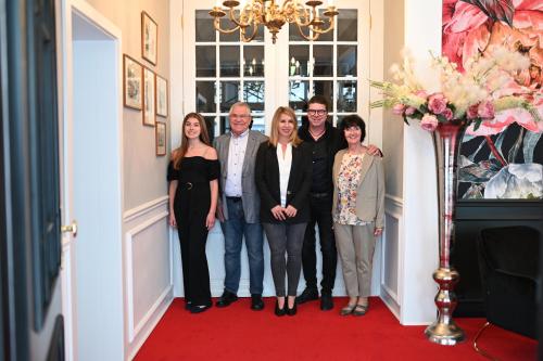 um grupo de pessoas posando para uma foto em um corredor em Boutique-Hotel Stadtvilla Hodes em Fulda