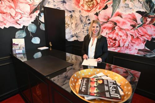 a woman standing in front of a table with a cake at Boutique-Hotel Stadtvilla Hodes in Fulda