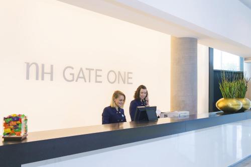 two women standing at a counter in a lobby at NH Bratislava Gate One in Bratislava