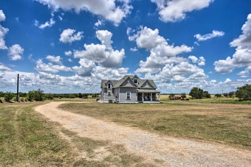 a house on a field with a dirt road at Decatur Farmhouse Getaway with Deck and Backyard in Decatur