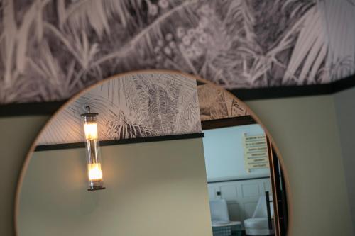 a mirror with a light in front of a wall at Grand Hôtel Bristol in Colmar