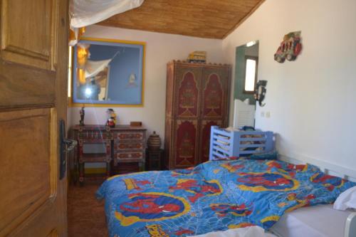 a bedroom with a bed with a blue comforter at Fabuleuse Villa Keur Bibou in Dakar