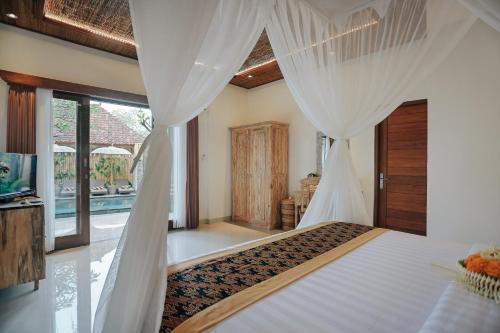 a bedroom with a bed with curtains and a pool at Sitala Suite in Ubud