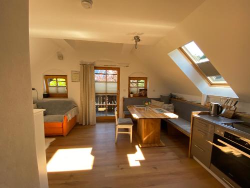 Fewo Martiner في Ferndorf: مطبخ وغرفة معيشة مع طاولة وأريكة