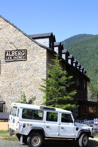 a white jeep parked in front of a building at Alberg Les Daines in Espot