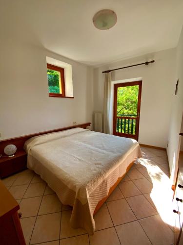 a bedroom with a large bed and a window at casa alla Valle in Salò