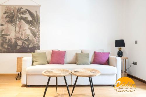 a living room with a white couch and two tables at Corazon del Mar - FREE PARKING by Cadiz Time in Cádiz