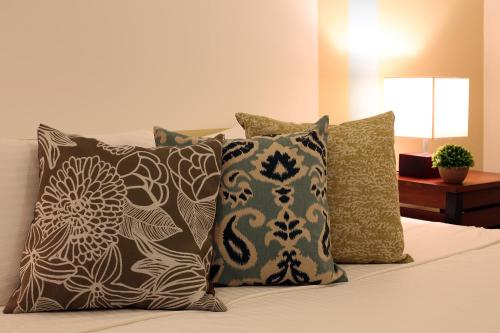 a bed with four pillows on it with at Iddamal Apartments in Mount Lavinia