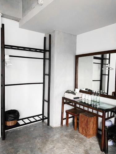 a dining room with a table and a mirror at Lamphu House Chiang Mai in Chiang Mai
