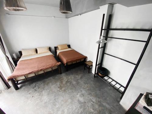 a room with two beds and a ladder in it at Lamphu House Chiang Mai in Chiang Mai