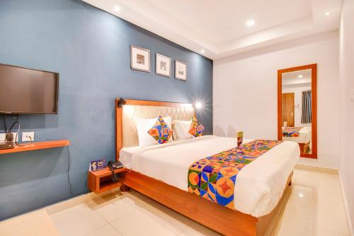 a bedroom with a large bed and a tv at FabHotel The Sun Suites - Yelahanka in Yelahanka