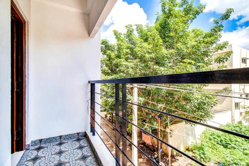 Elle comprend un balcon offrant une vue sur un arbre. dans l'établissement FabHotel The Sun Suites Vinayaka Nagar, à Yelahanka