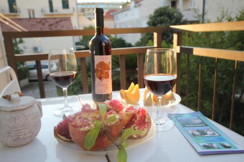 a table with a bottle of wine and two glasses at Guest House Vila Micika Dubrovnik in Dubrovnik