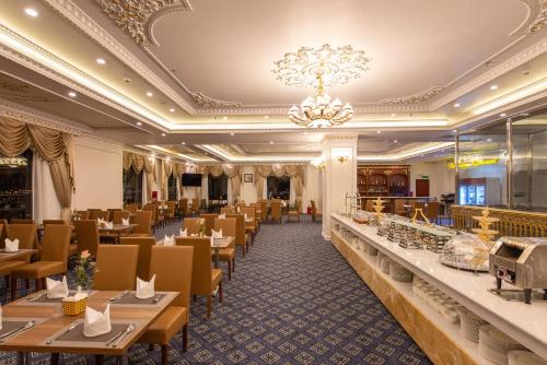 a restaurant with tables and chairs and a chandelier at THE SHINE HOTEL in Hai Phong