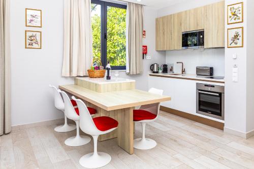 a kitchen with a wooden table and white chairs at Fazenda Viegas in Lagos