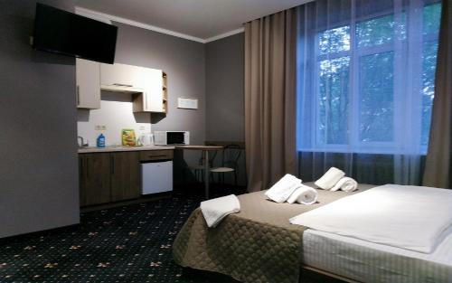 ein Hotelzimmer mit einem Bett und einer Küche in der Unterkunft Luxury.ap in Iwano-Frankiwsk