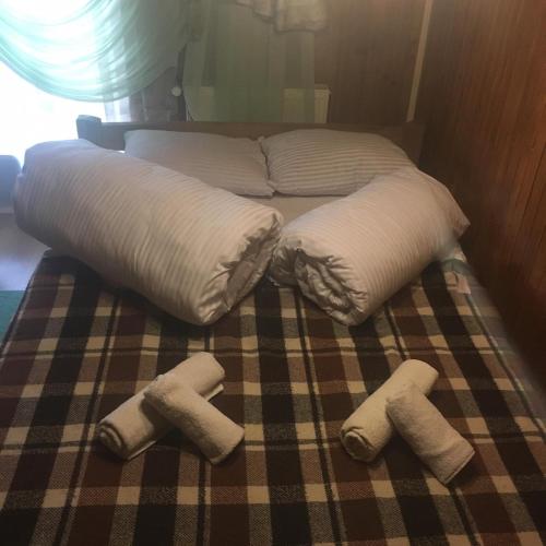 a bed with three pillows and towels on it at Sadyba Pidkova Чан сауна Приймаємо групи до 70людей in Pistyn