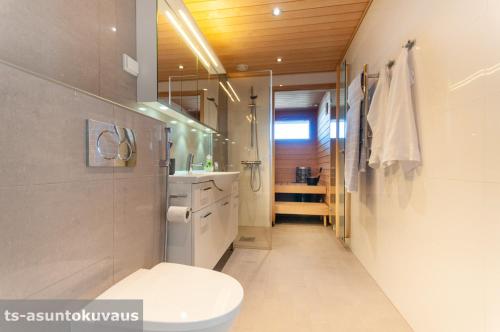 a bathroom with a toilet and a sink and a mirror at The Best View in Turku with private balcony, sauna, car park in Turku