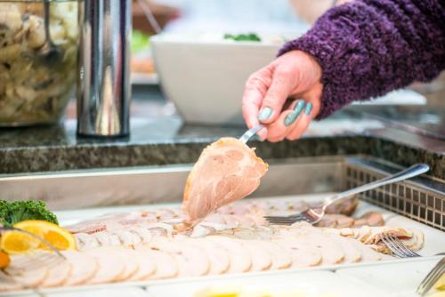 Una persona está preparando un trozo de carne en una mesa. en Dozamel, en Kołobrzeg