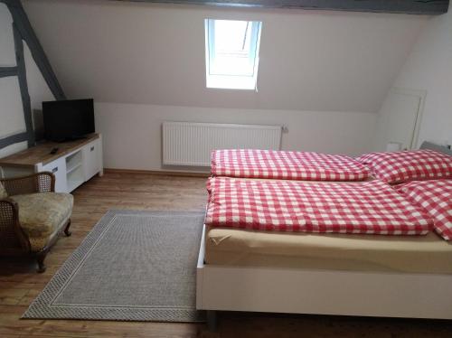 a bedroom with a bed with a red and white blanket at Hof Bauer in Zaisenhausen