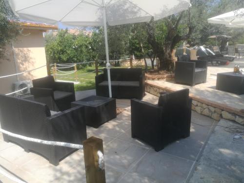 a group of chairs and an umbrella on a patio at B&B Marino in Grisolia