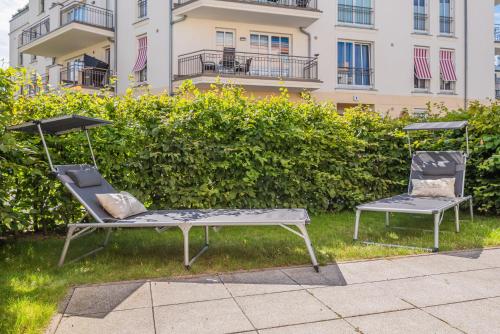 dos sillas sentadas en el césped frente a un edificio en Villa Seeadler, en Börgerende-Rethwisch