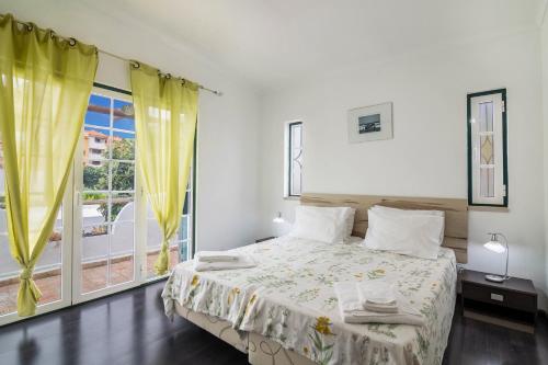 a bedroom with a bed and a large window at Villa Sunflower in Albufeira