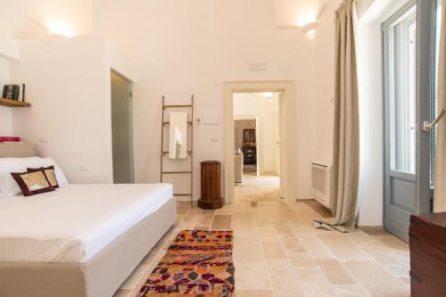 a bedroom with a white bed and a rug at Masseria Limonaia & Spa in Fasano