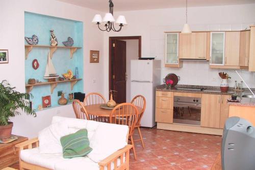 een keuken met een witte bank en een tafel met stoelen bij Casa Karen in Vallehermoso