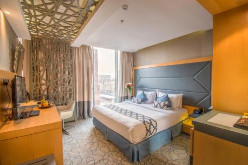 فندق جراند بلازا - الخليج الرياض في الرياض: غرفة فندقية بسرير كبير ونافذة