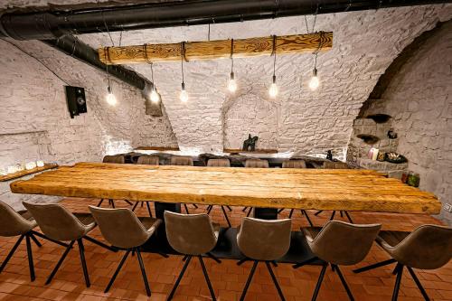 a large wooden table in a room with chairs at DOMA u nás Boutique hotel & spa in Poprad