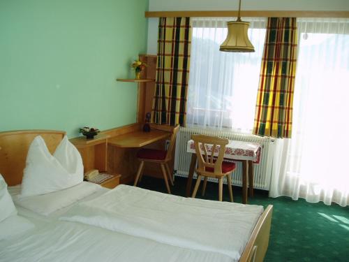 a bedroom with a bed and a desk and a table at Ausflugshotel Huttersberg in Kirchdorf an der Krems