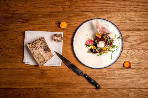 a plate of food and a knife on a table at DOMA u nás Boutique hotel & spa in Poprad