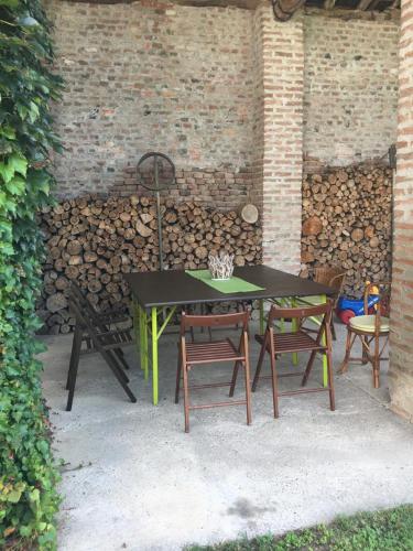 a table and chairs sitting under a brick wall at THE BERGHOUSE - LA CASA SUL CLIVO with JACUZZI in Bergamasco