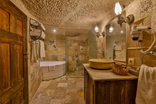 y baño con lavabo, bañera y ducha. en Hidden Cave Hotel, en Göreme