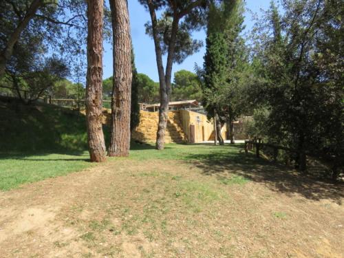 a yard with trees and a house in the background at Europe tents camping Begur in Begur