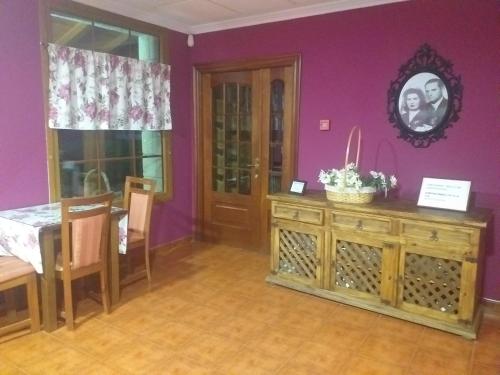 una sala da pranzo con tavolo e parete viola di Hotel Artea Errota a Zamudio