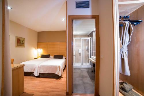 1 dormitorio con 1 cama y baño en Hotel Serrano, en Córdoba