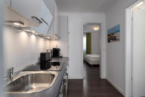 Ferienwohnungen Rosengarten في بورغيريندي-ريثفيش: مطبخ مع حوض حديد قابل للصدأ في الغرفة