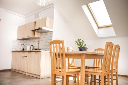 cocina con mesa de madera y sillas en Apartamenty Willa Pogoń en Krynica Zdrój