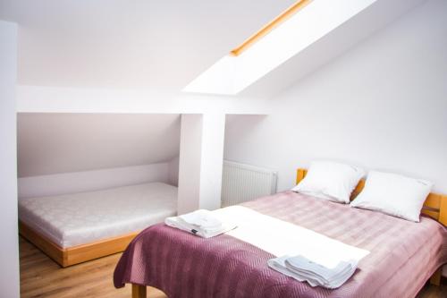 pokój z dwoma łóżkami i łóżkiem sidx sidx sidx w obiekcie Apartamenty Willa Pogoń w mieście Krynica Zdrój