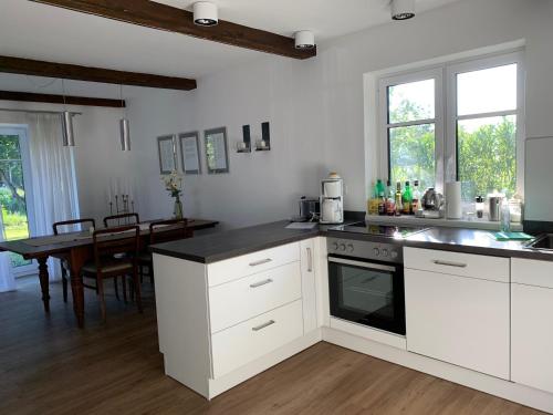 a kitchen with white cabinets and a black counter top at Charmantes Haus mit zwei Ferienwohnungen und großem Garten in Aventoft - Enjoy! in Aventoft
