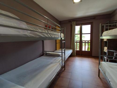 two bunk beds in a room with a window at Alberg Les Daines in Espot