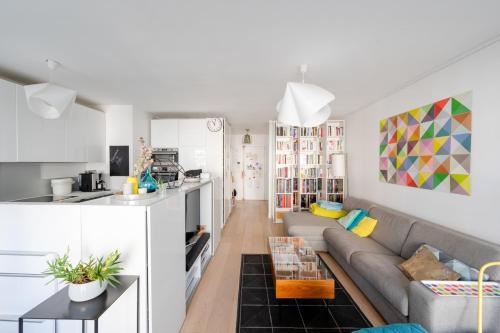 ein Wohnzimmer mit einem Sofa und einer Küche in der Unterkunft Beautiful Apt With Balcony Parc Montsouris Rer B in Paris