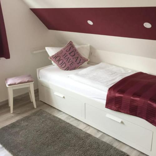 a white bed with a pillow and a chair at Ferienhaus Godewind in Kühlungsborn