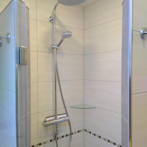 a shower with a glass door in a bathroom at Ferienhaus Godewind in Kühlungsborn