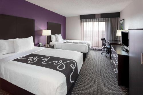 ein Hotelzimmer mit 2 Betten und einem Schreibtisch in der Unterkunft La Quinta by Wyndham Minneapolis Bloomington W in Bloomington