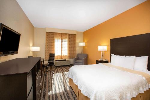 a hotel room with a bed and a flat screen tv at La Quinta Inn by Wyndham Lincoln in Lincoln